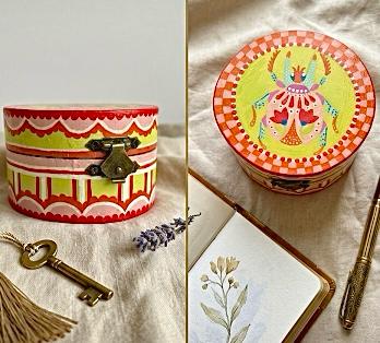 A pair of small hand-painted trinket boxes, an oval striped one and a round scarab one.